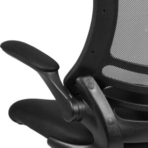 A close-up shot from behind a black ergonomic office chair, showing the mechanism of a padded flip-up armrest next to the breathable mesh backrest and contoured lumbar support structure.